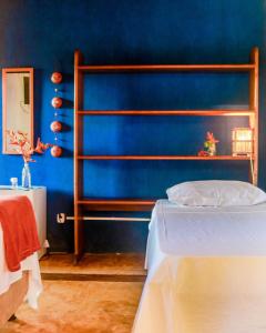 伊塔卡雷Pousada Guaiamum的蓝色的卧室,配有床和蓝色的墙壁