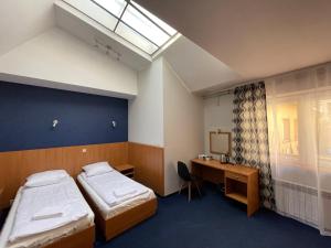 克拉科夫Garbarska 22 Aparthotel的客房设有两张床、一张桌子和一个窗户。