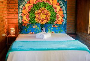伊塔卡雷Pousada Guaiamum的一张带两条毛巾的床,带花卉床头板