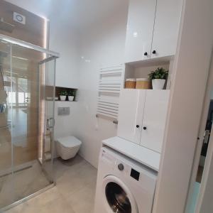 兹沃图夫Lux Apartment parking gratis的白色的浴室设有洗衣机和卫生间。