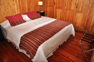圣卡洛斯-德巴里洛切修道院精品酒店的木墙客房内的一张大床