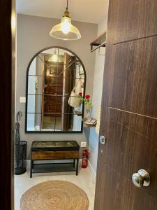 贝哈尔El Rinconcito de Bejar的浴室设有镜子,门前设有长凳