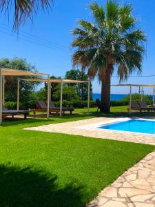 瓦尔索洛米翁Glyfa Beach Hotel的棕榈树和游泳池的度假村