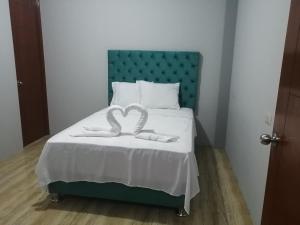 塔拉波托Apartamento familiar的一间卧室配有一张带绿色床头板的床