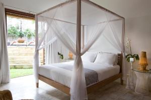 坎古Sound of The Sea Villa的一间卧室配有一张天蓬床和窗户