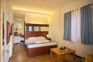 邦劳Siman Panglao的酒店客房配有一张床铺和一张桌子。