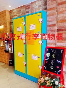 台北V-one - 宁夏2号旅店的两个黄色和蓝色的储物柜位于客房内