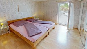 小布利特斯多夫Lorth´s Inn Ferienwohnung的一间卧室配有一张带紫色枕头的床