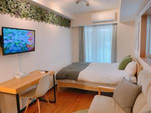 东京Dash Living Shinjuku的一间卧室配有一张床和一张书桌