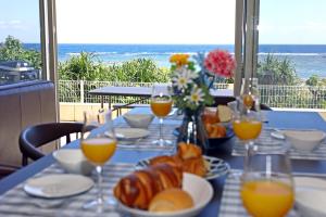 德之岛オーシャンヴィラ徳之島-Ocean Villa Tokunoshima-的餐桌,带食物和橙汁杯