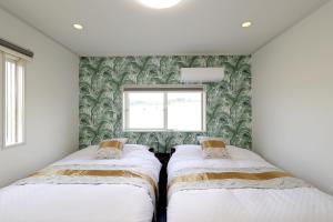 德之岛オーシャンヴィラ徳之島-Ocean Villa Tokunoshima-的小型客房 - 带2张床和窗户