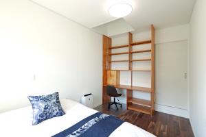 德之岛オーシャンヴィラ徳之島-Ocean Villa Tokunoshima-的一间小卧室,配有一张床和一张书桌