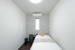 德之岛オーシャンヴィラ徳之島-Ocean Villa Tokunoshima-的一间小卧室,配有床和窗户