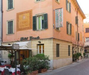 维罗纳Hotel Torcolo "Residenze del Cuore"的城市街道上设有餐厅的建筑
