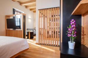 基亚文纳Villa Giade的一间卧室配有一张床、一台电视和鲜花