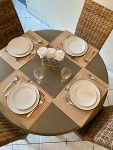 迪耶普Superbe appartement entre mer et ville的一张桌子,上面有白色的盘子和餐具