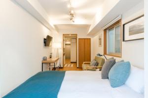 东京Dash Living Shinjuku的一间卧室配有一张带蓝色枕头的大床