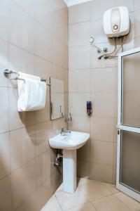 达累斯萨拉姆机场中转山林小屋的一间带水槽、镜子和毛巾的浴室