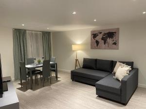 伦敦City airport serviced apartment London的客厅配有沙发和桌子