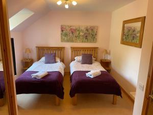斯佩河畔格兰敦Tulach Ard的紫色床单间内的两张单人床