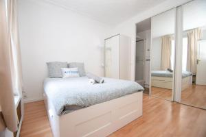 万塞讷Top location near ParisSuperb cosy 2p apartment的白色卧室配有床和镜子