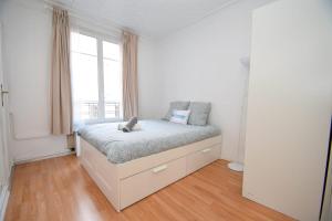 万塞讷Top location near ParisSuperb cosy 2p apartment的白色卧室设有一张带窗户的床