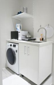 新加坡Comfy Studio 7 by ReCharge的厨房配有洗衣机和水槽