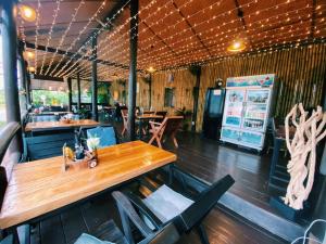 普吉镇ViVi Hotel Resort的餐厅配有木桌和椅子