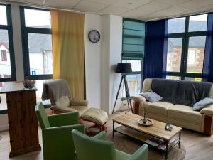 佩罗斯-吉雷克Appartement LE TRITON的带沙发、椅子和时钟的客厅