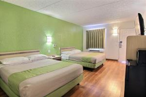 奥斯汀Motel 6 Austin, TX - Central Downtown UT的绿墙客房内的两张床