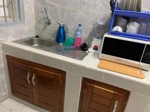 科托努PARADISE 2的厨房柜台设有水槽和微波炉