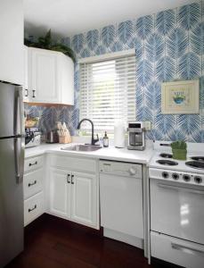 基韦斯特Duval Street Suite with pool的厨房配有白色橱柜和蓝白壁纸