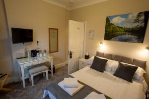 Parkend狄恩菲尔德酒店的一间卧室配有一张床、一张书桌和一台电视