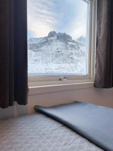 FjordgårdSegla Guesthouse - with view of Fjord的窗户享有雪覆盖的山脉美景