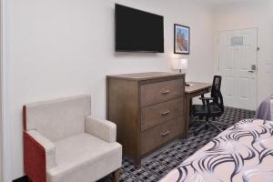亨博尔Americas Inn & Suites IAH North的酒店客房配有书桌和椅子