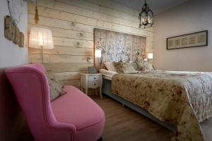 舍夫德Karstorp Säteri – Hotell och Konferens的一间卧室配有一张床和一张粉红色的椅子