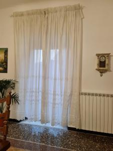 热那亚WOW HOME 2 - 175 mq - posteggio privato - davanti porto traghetti - fino a 10 posti letto - balcone的暖气室内的白色窗帘