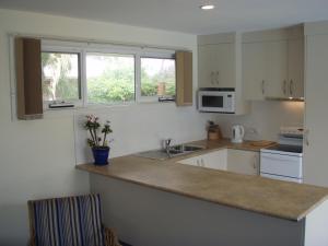 Sandford班布拉礁度假屋的厨房配有白色橱柜和台面