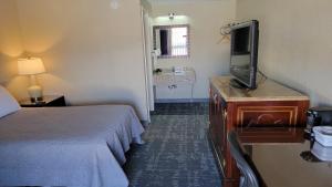 班戈Queen City Inn的配有一张床和一台平面电视的酒店客房