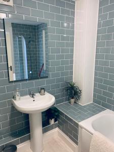 利夫顿Little Bere apartment的浴室配有盥洗盆、镜子和浴缸