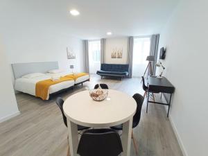 丰沙尔Tanoeiros Studios的酒店客房配有一张床铺、一张桌子和一张书桌。