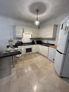 圣克鲁斯-德特内里费DREAM BULEVAR的厨房配有白色橱柜和白色冰箱。