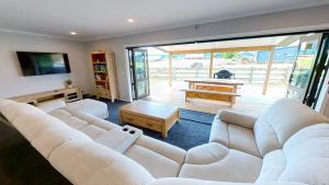 奥阿库尼Ohakune Solar on Snowmass的客厅配有白色的沙发和桌子