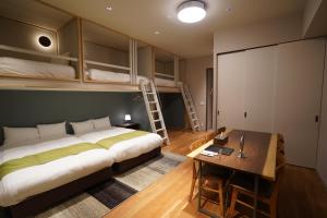 札幌Riverside Hotel Sapporo的一间卧室配有一张床、一张书桌和双层床。