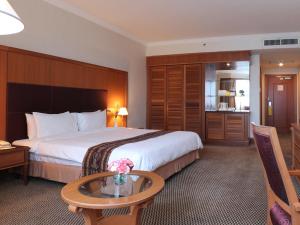 米里米里帝国酒店的酒店客房设有一张大床和一张桌子。