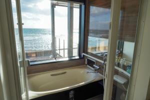 函馆Sinori205的带浴缸的浴室和海景窗户。