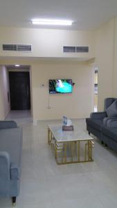 阿吉曼Al Rawda Apartments -Ajman的带沙发和咖啡桌的客厅
