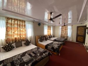 斯利那加Hotel Young Mamta的带窗户和窗帘的客房内的三张床