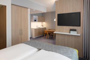 奥夫特林根Holiday Inn Express - Aarburg - Oftringen, an IHG Hotel的配有一张床和一台平面电视的酒店客房