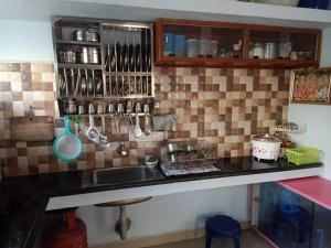 耶拉吉里Yelagiri RAM Cottage @Home with kitchenette full的厨房配有水槽和带餐具的台面